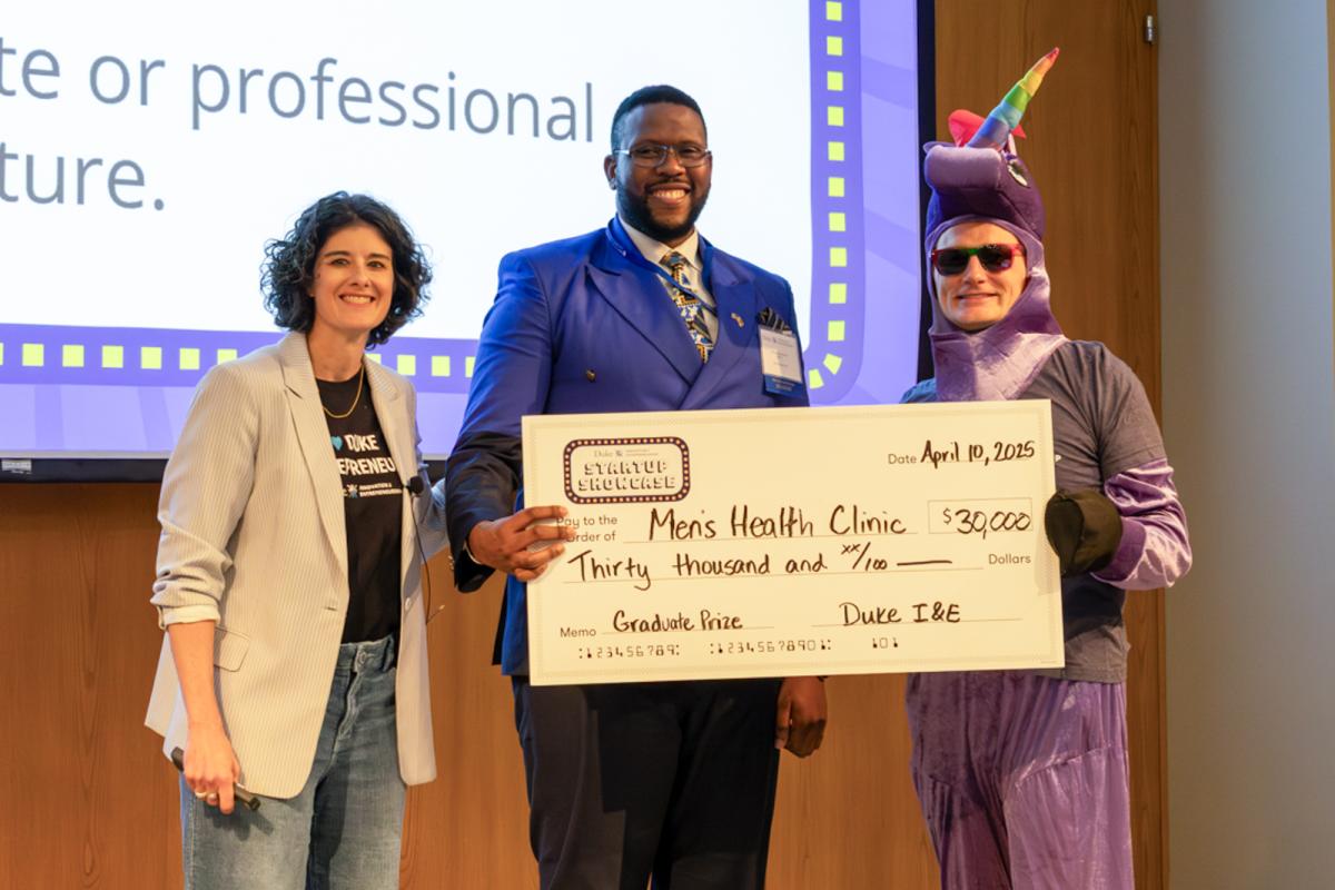 Ben Ncube holds a check for his venture, Men's Health Clinic, at the 2025 Duke Startup Showcase