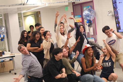 Students celebrating in the Duke I&E Bullpen, throwing hands in the air